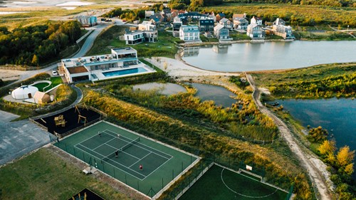 Aerial view of Silverlake showing tennis courts, lake and properties